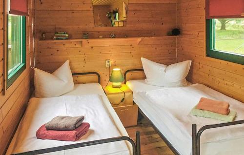 a room with two beds in a wooden cabin at 1 Bedroom Cozy stacaravan In Warthe in Warthe