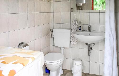 a bathroom with a toilet and a sink at 1 Bedroom Cozy stacaravan In Warthe in Warthe