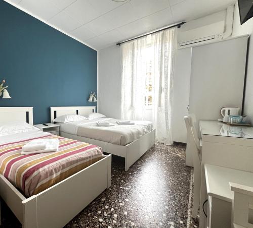 2 łóżka w pokoju z niebieskimi ścianami w obiekcie Hotel Baia di Levanto w mieście Levanto