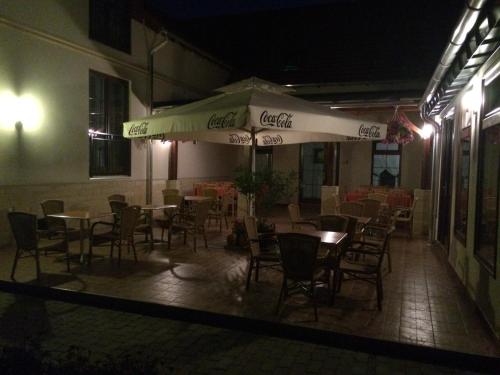 a restaurant with tables and chairs and an umbrella at Meggyes Hotel in Szerencs