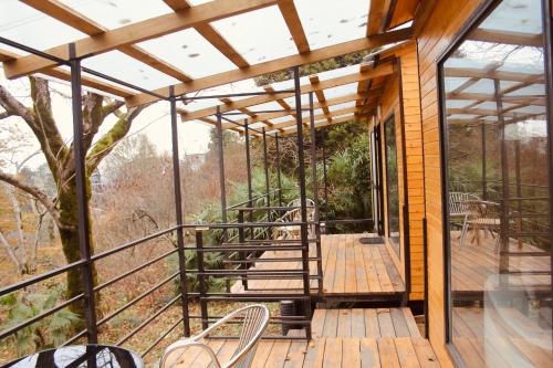 a wooden deck with chairs and tables on it at Kottage anania in Batumi