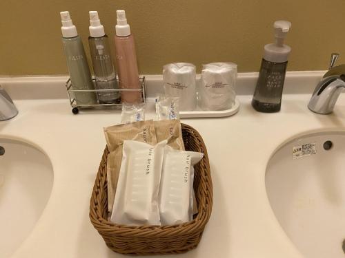 a basket of toothbrushes sitting on top of a sink at Hakone Kowakien Miyamafurin in Hakone