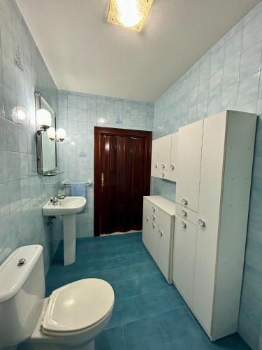 a bathroom with a white toilet and a sink at Del Valle 3 in Cudillero