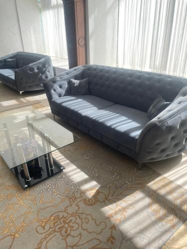 a living room with a leather couch and a table at Hotel Parc in Craiova