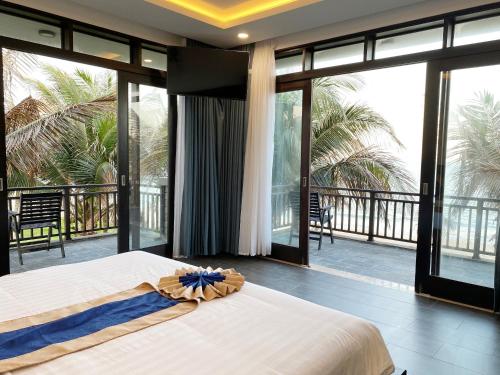 una camera con letto e un balcone con porte scorrevoli in vetro di Starlight Villa Beach Resort & Spa a Phan Thiet