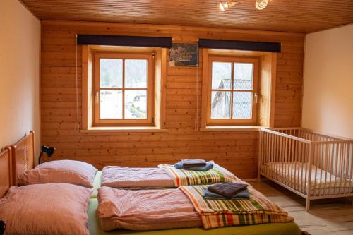 1 Schlafzimmer mit 2 Betten in einem Zimmer mit Fenstern in der Unterkunft Apartment Haider 1 in Obertraun