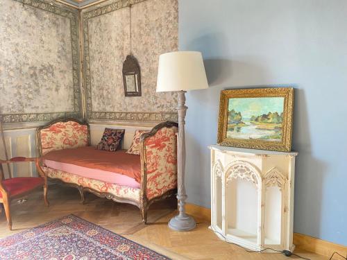 une chambre avec une chaise, une lampe et un tableau dans l'établissement Gorgeous old house in the centre of Souillac, à Souillac