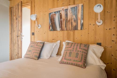 a bedroom with a white bed with wooden walls at La Maison Rouge in Barberaz