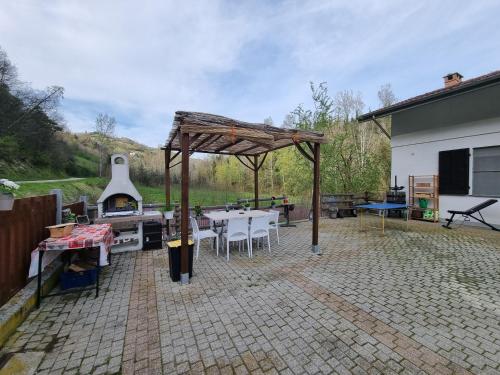 patio ze sprzętem do grillowania, stołem i krzesłami w obiekcie Ospitalità Agricola di Langa Alloggio Mansardato Vacanze w mieście Sinio