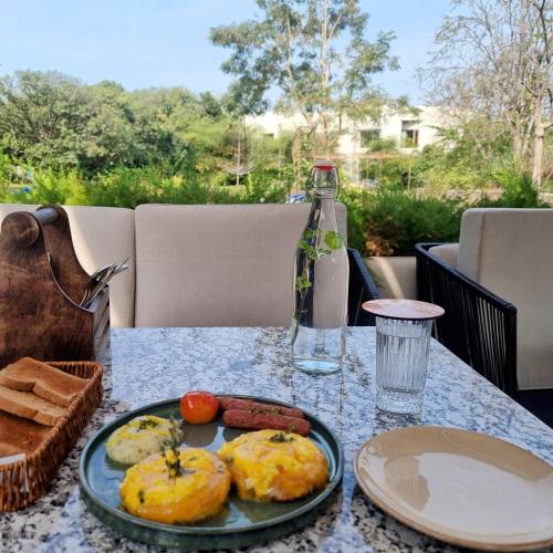 a table with a plate of food on a table at Giovanni Village Resort in Bhopal