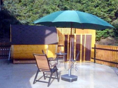 a patio with two chairs and a large umbrella at Penzion Terasa při Rybářském a cyklistickém centru in Chlum u Třeboně