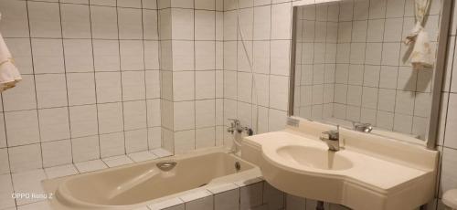 a white bathroom with a sink and a tub at Melody Hawaii Hotel in Taitung City