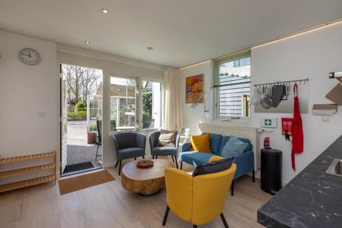 a living room with a blue couch and chairs at Welcome in - Vakantiehuis - Middelburgsestraat 61a - Koudekerke 'Villa Querina' in Koudekerke