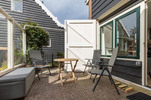 a patio with chairs and a table next to a house at Welcome in - Vakantiehuis - Middelburgsestraat 61a - Koudekerke 'Villa Querina' in Koudekerke