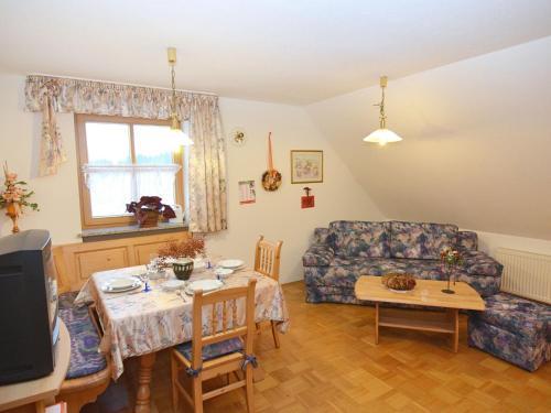 a living room with a couch and a table at Spacious Apartment with Sauna in Schonsee in Dietersdorf