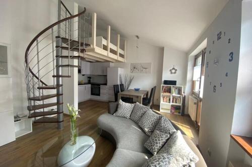 a living room with a couch and a spiral staircase at Ferienwohnung im Ferienpark Falkenstein in Falkenstein