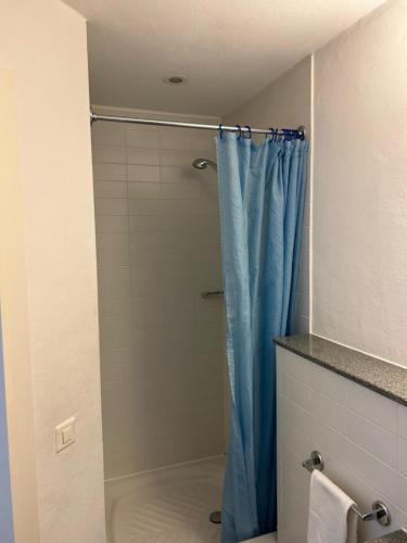 a bathroom with a shower with a blue shower curtain at Hotel Domicil in Frauenfeld