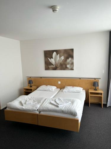 a bedroom with a bed with white sheets and pillows at Hotel Domicil in Frauenfeld
