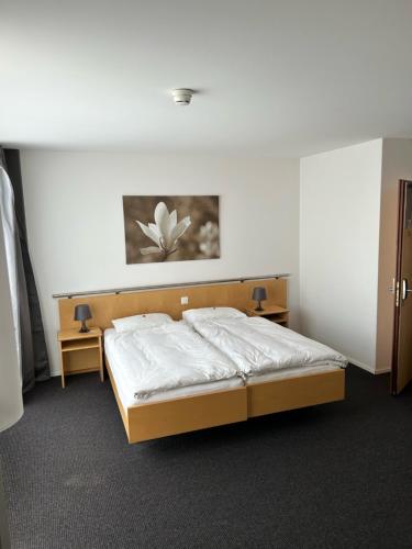 a bedroom with a bed and two tables in it at Hotel Domicil in Frauenfeld