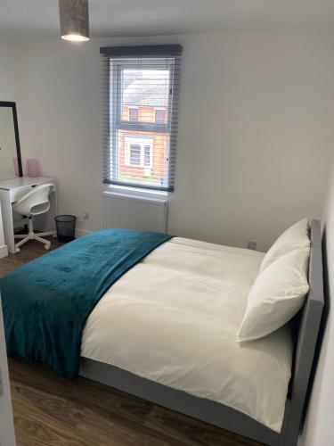 um quarto com uma cama branca e um cobertor azul em Heart of Oxford em Oxford
