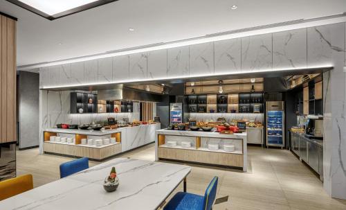 a large kitchen with tables and chairs in a room at Hyatt Place Makassar in Makassar