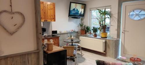 a living room with a table and a tv on the wall at Wohnung am Wanderweg zum Königsstuhl unter Reet in Lohme