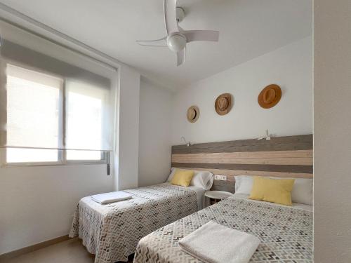 una camera con 2 letti e un ventilatore a soffitto di Duna de arenales ad Arenales del Sol