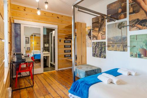 two beds in a room with a desk and a desk at Daddy Long Legs Art Hotel in Cape Town