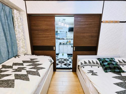 a bedroom with two twin beds and a hallway at Downtown Tokyo/Taito-gu/2min walk nearest sta/Ueno/Wi-Fi/302 in Tokyo