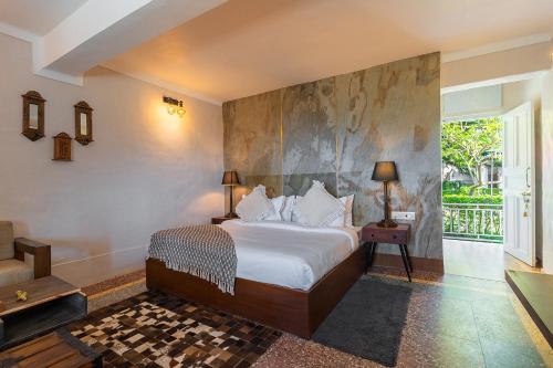 Un dormitorio con una cama grande y una pared en MAATI - Signature Collection by Eight Continents, en Nainital