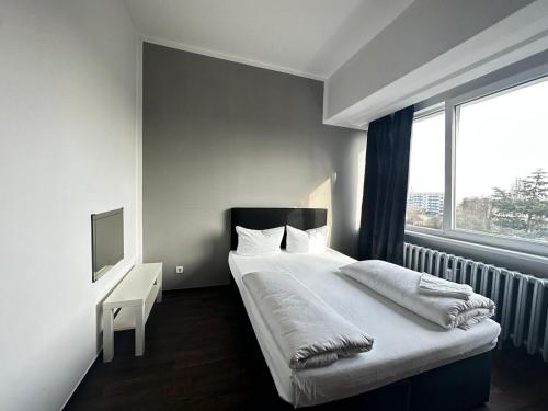 Schlafzimmer mit einem großen Bett und einem Fenster in der Unterkunft Ootel.com in Berlin