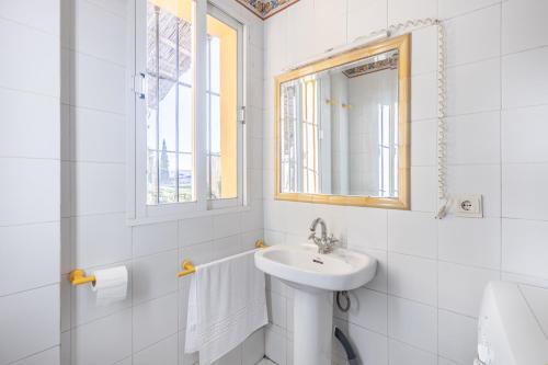 un bagno bianco con lavandino e specchio di AA Guest - Veleta del Jardín de Sierra Nevada ad Alhendín