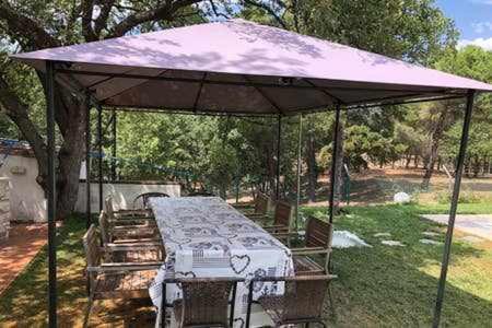 una mesa de picnic bajo un dosel en un patio en Casa Bellavista con piscina en Caldes Costa Brava en Caldes de Malavella