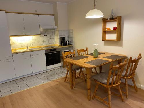 Ferienresidenz-an-der-Bode-Wohnung-2 في برونلاغ: مطبخ مع طاولة وكراسي خشبية في مطبخ