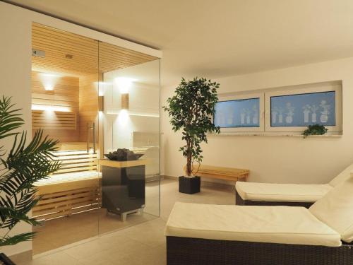 Ferienresidenz-an-der-Bode-Wohnung-2 في برونلاغ: غرفة معيشة بها أريكة بيضاء وزرع