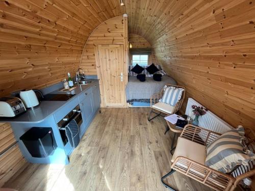 a kitchen and living room in a log cabin at The Pod Patch - Trelerney Pod in Bishops Castle