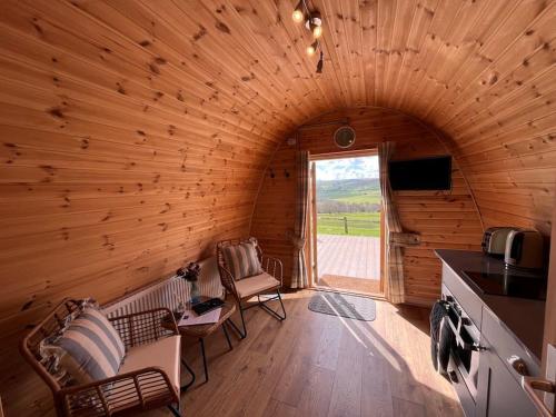 a log cabin with a kitchen and a window at The Pod Patch - Trelerney Pod in Bishops Castle