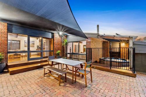 a patio with a table and a bench at Beachside Weekender Retreat with Spa sleeps 11-13 in Ocean Grove