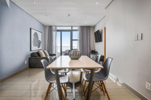 a dining room and living room with a table and chairs at The Capital Pearls Hotel in Durban