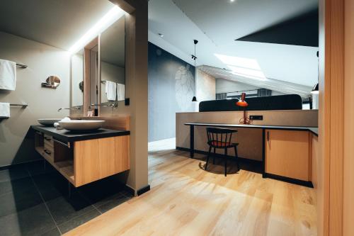 La salle de bains est pourvue d'un lavabo et d'un comptoir avec une table. dans l'établissement Hotel Zum Goldenen Hirsch, à Sonthofen