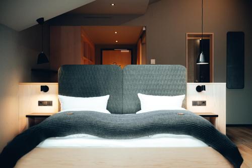 a bedroom with a large bed with a green headboard at Hotel Zum Goldenen Hirsch in Sonthofen