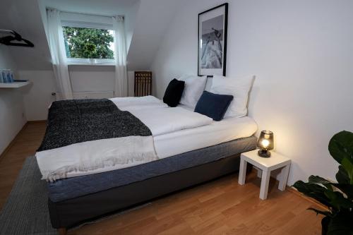 um quarto com uma cama grande com lençóis brancos e almofadas azuis em Stadtoase nähe Uni Design Wohnung mit 2 Schlafzimmern & Sauna em Koblenz