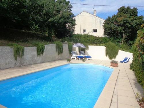 a swimming pool with two blue chairs and a house at LE HAVRE DE PAIX in Peypin