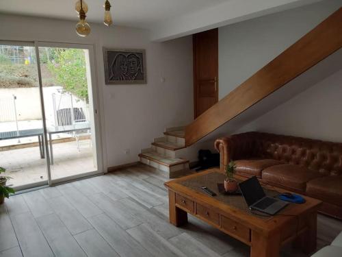 a living room with a couch and a table with a laptop at LE HAVRE DE PAIX in Peypin