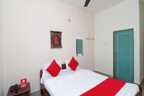 a bedroom with two beds with red pillows at Hotel Padoshi Puri Near Sea Beach & Temple - Parking Facilities - Best Hotel in Puri in Puri