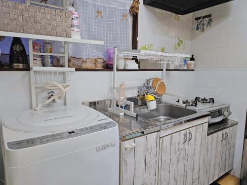 uma pequena cozinha com um lavatório e uma máquina de lavar louça em Downtown Tokyo/Taito-gu/2min walk nearest sta/Ueno/Wi-Fi/302 em Tóquio