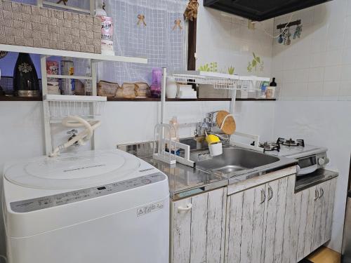 a small kitchen with a sink and a dishwasher at Downtown Tokyo/Taito-gu/2min walk nearest sta/Ueno/Wi-Fi/302 in Tokyo