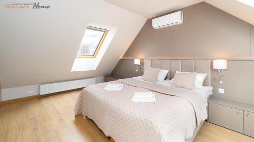 a bedroom with a large bed and a window at Wonder Home - Domki Hillside tuż przy stoku narciarskim - na terenie kompleksu plac zabaw i zewnętrzna siłownia, sklep, parking in Karpacz