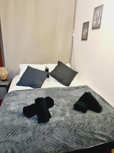a bedroom with a bed with two black hats on it at L'anjou - St Nazaire - Comme à la maison in Saint-Nazaire
