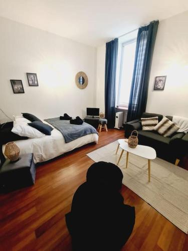 a living room with a bed and a couch at L'anjou - St Nazaire - Comme à la maison in Saint-Nazaire